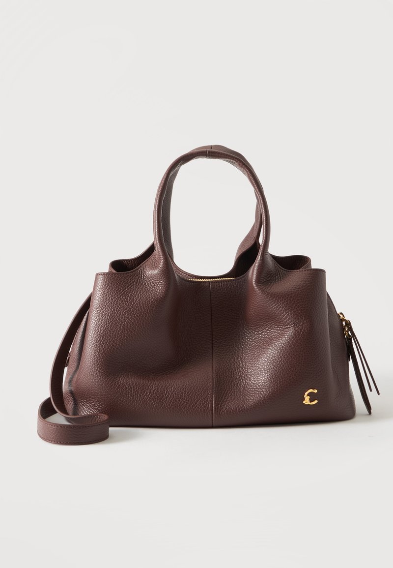 Sac à main en cuir texturé marron foncé avec deux poignées, une bandoulière amovible et un petit logo doré "C" en bas à droite.