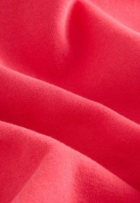 Tissu rose corail, texture douce, trame fine et serrée, surface lisse avec un léger éclat et un tombé délicat, adapté pour les vêtements ou la tapisserie.