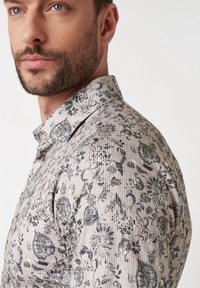Lichtgekleurde overhemden met een florale en paisleyprint in marineblauw. Heeft een textuurstof en een normale kraag.