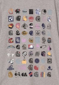 Tela gris que presenta 64 diseños gráficos en varios colores y estilos, incluyendo símbolos, patrones y logotipos, dispuestos en un diseño de cuadrícula.