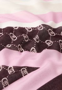 Tessuto con strisce alternate di rosa, bianco e marrone, con un motivo di logo ripetuto in bianco nelle sezioni marroni. Texture morbida.