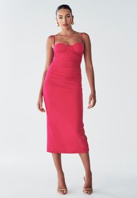 Fitted, strapless midi dress in bright pink, featuring ruched detailing and a sweetheart neckline. Smooth fabric with a sleek silhouette.