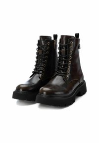 Botas de tobillo de cuero marrón con una suela negra resistente, que cuentan con ojales de metal, cordones y un cierre de cremallera en el lado para facilitar su uso.
