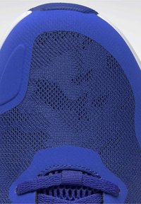 Modrý sportovní botník vyrobený z texturovaného síťovaného materiálu s maskáčovým vzorem, hladkými syntetickými akcenty a kulatým, polstrovaným límcem.