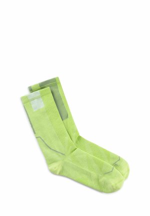 Par de calcetines hasta la mitad de la pantorrilla de color verde lima con patrones geométricos claros y oscuros, colocados planos sobre un fondo blanco.