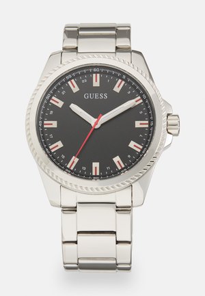 Sølv rustfritt stålklokke med svart skive, røde detaljer og hvite timemarkører. Har en teksturert bezel og lenkearmbånd.