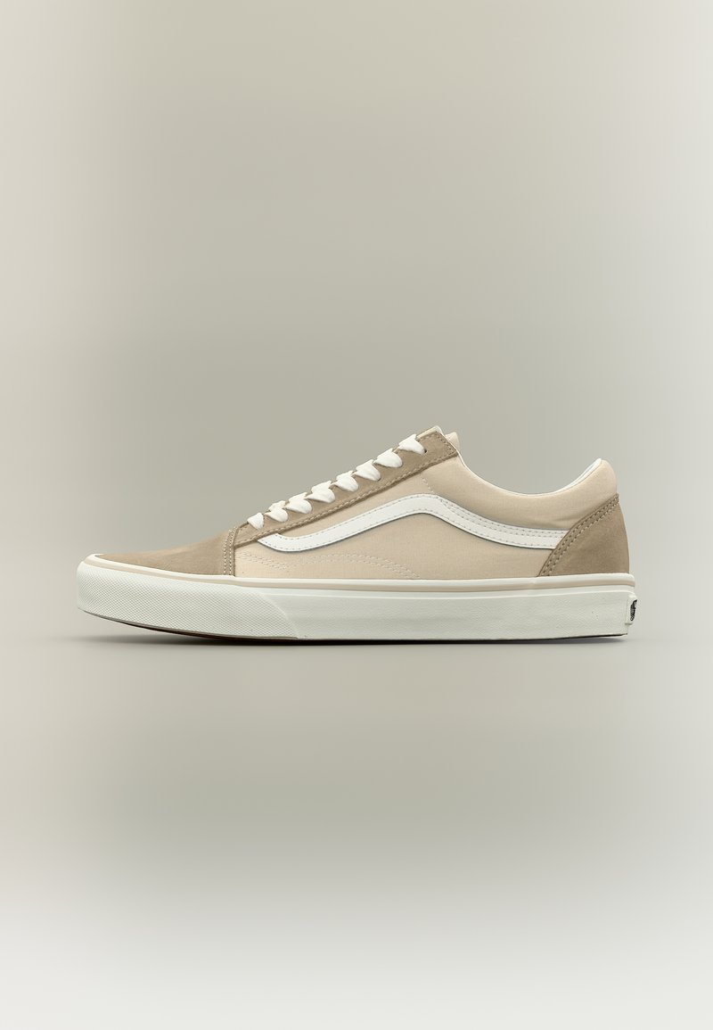 Μπεζ sneaker χαμηλού προφίλ με λευκή πλευρική ρίγα, λευκά κορδόνια και λευκή λαστιχένια σόλα σε ουδέτερο φόντο.