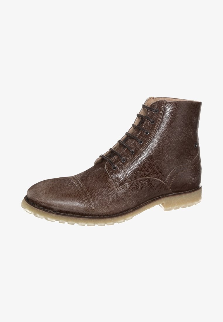 Bota de tobillo de cuero marrón con un acabado texturizado, punta redonda, seis ojales y una suela de goma translúcida. Presenta detalles de costura mínimos.