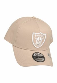 Berretto da baseball beige con il logo dei Raiders ricamato in bianco sulla parte frontale. Caratterizzato da un design strutturato, visiera curvata e cinturino regolabile.
