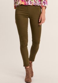 Pantaloni aderenti verde oliva realizzati in tessuto elasticizzato, con un design classico, vita media e taglio alla caviglia.