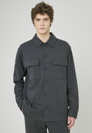 Chemise boutonnée gris foncé en tissu doux, dotée d'un col, de deux poches poitrine et de manches longues, assortie à un pantalon identique.