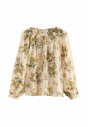 Blouse beige transparente à manches longues avec imprimé floral, encolure smockée et détail noué devant.