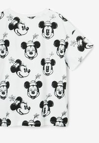 Camiseta blanca de manga corta con un estampado repetido en negro de las caras de Mickey y Minnie Mouse, acentuado por pequeñas flores. Material de algodón suave.