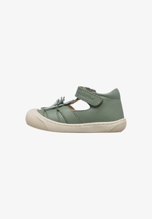 Scarpa verde per bambino con tallone chiuso, lati aperti, cinturino anteriore con frange e suola in gomma beige con paraurti anteriore.