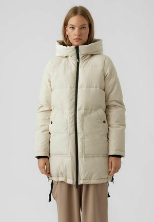 Beige gewatteerde parka met een ritssluiting aan de voorkant, grote capuchon, zijzakken en zwarte hardware accenten. Voorzien van trekkoorden aan de onderkant voor verstelbaarheid.