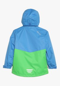 Giacca impermeabile blu e verde con cappuccio, caratterizzata da un design a blocchi di colore e polsini elastici. Logo stampato vicino al collo, accentuazione riflettente nella parte inferiore.