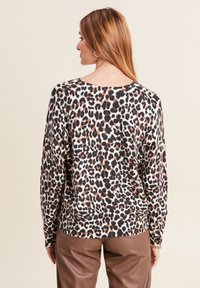 Leopardenmuster-Pullover mit lockerer Passform, langen Ärmeln und weitem Ausschnitt. Verfügt über eine Kombination aus Schwarz, Braun und Creme in einem weichen Stoff.