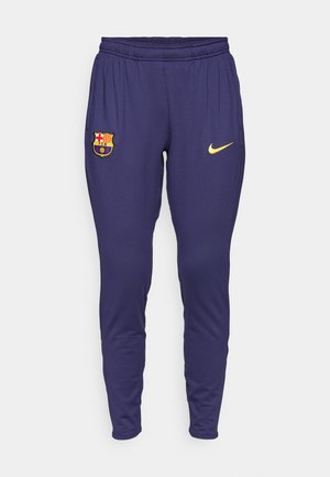 Navy athletic pants with an elastic waistband, featuring a yellow Nike logo and a multicolored FC Barcelona crest on the left thigh.