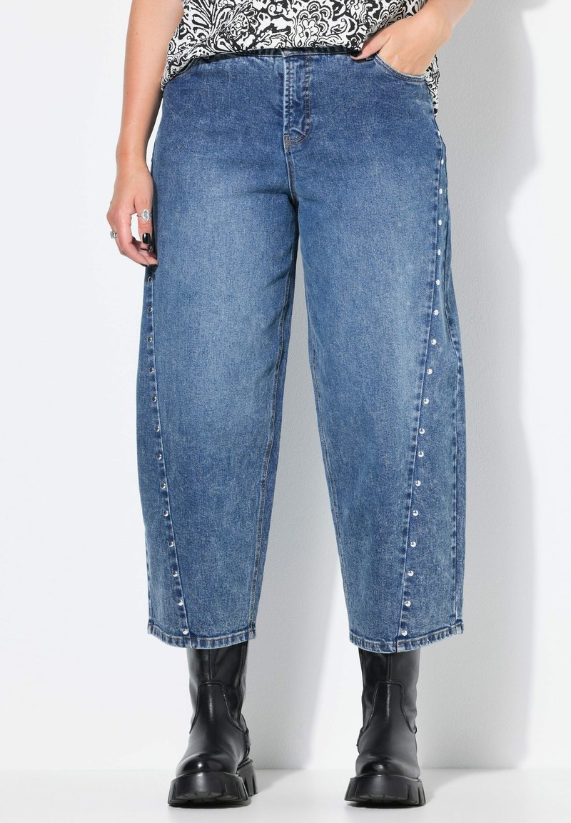 Svetle modré džínové široké kalhoty s vysokým pasem, bočními druky a jemným blednutím. Spárováno s černými kotníkovými botami.