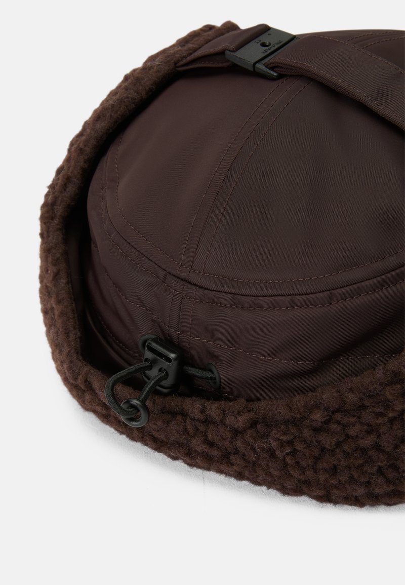 Brun hat med en glat, vandtæt overdel og en tekstureret, fleeceagtig nederdel, med snoretræk og justerbar lukning for pasform.
