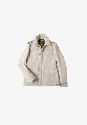 Jasno beżowa kurtka z zapięciem na zamek, dwoma kieszeniami na piersi i dwiema kieszeniami dolnymi. Posiada szeroki kołnierz i epolety na ramionach.