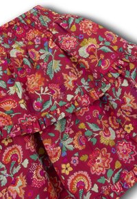Bloemrok in donkerroze stof met een geplooide taille, voorzien van meerkleurige patronen van bloemen en bladeren, en een gerimpelde rand.