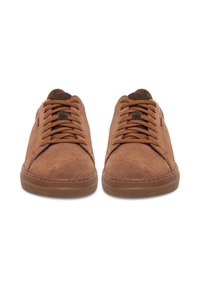 Adidași din suede maro cu vârf rotunjit, suprafață texturată și șireturi tonale. Au o talpă din cauciuc și accente de design minimalist.