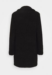 Abrigo exterior negro y peludo con una textura suave, de mangas largas y corte recto. Presenta un collar con muesca y un diseño de longitud media.