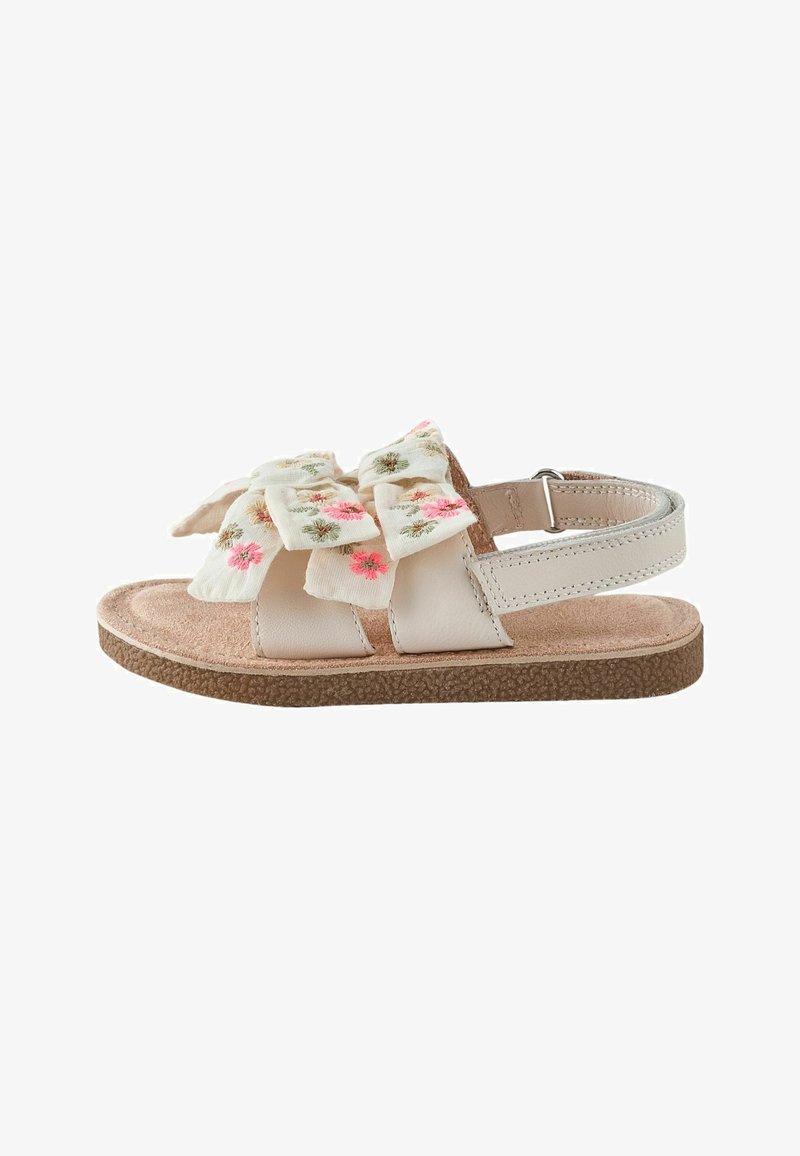 Sandale beige pour enfant avec semelle rembourrée, bride ajustable et nœuds en tissu ornés de broderies florales rose et verte.