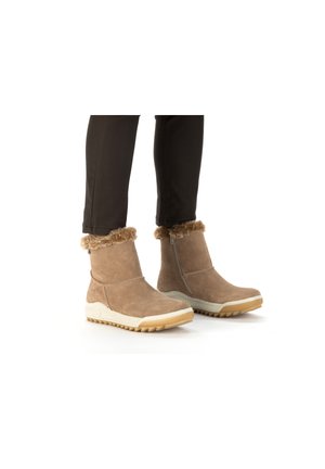Bottines en daim marron avec garniture en fausse fourrure, fermeture éclair latérale, semelle en caoutchouc texturée et détail de semelle intermédiaire blanche contrastante.