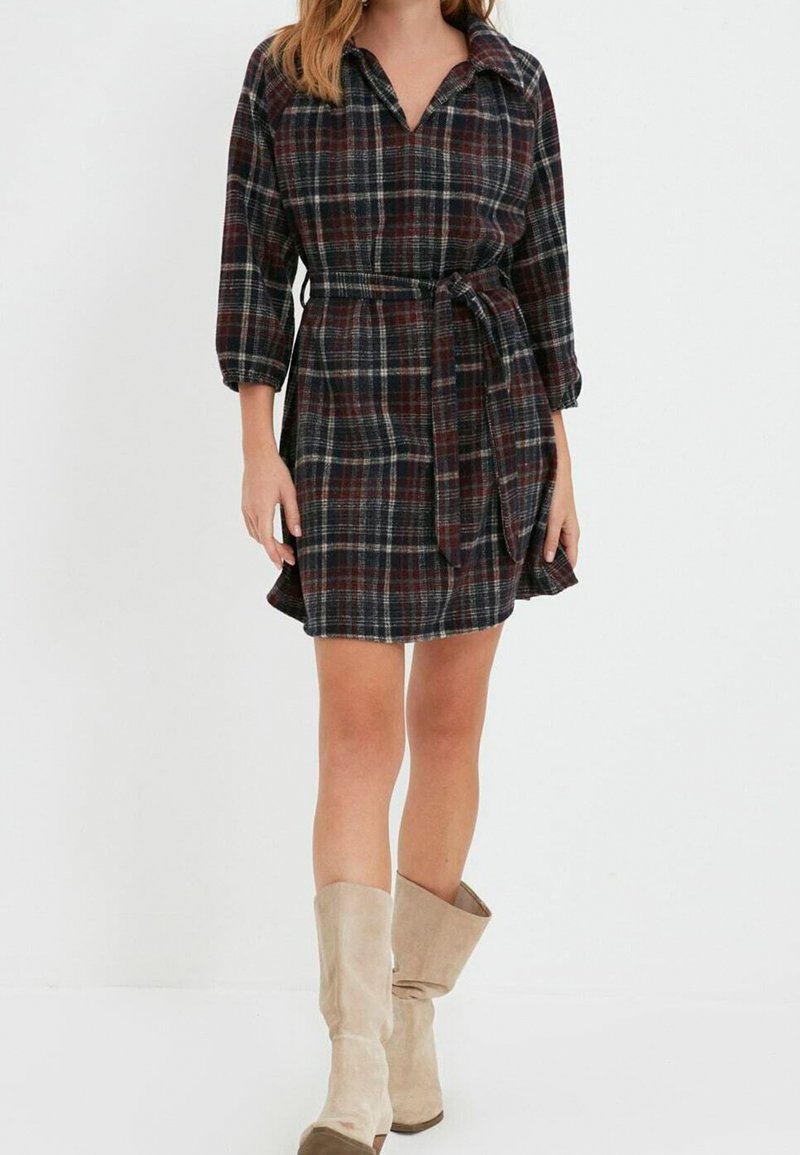 Kostkované šaty v námořnické modři, burgundské a bílé barvě s límečkem, dlouhými rukávy a odpovídajícím páskem. Měkká tkanina s uvolněným střihem.