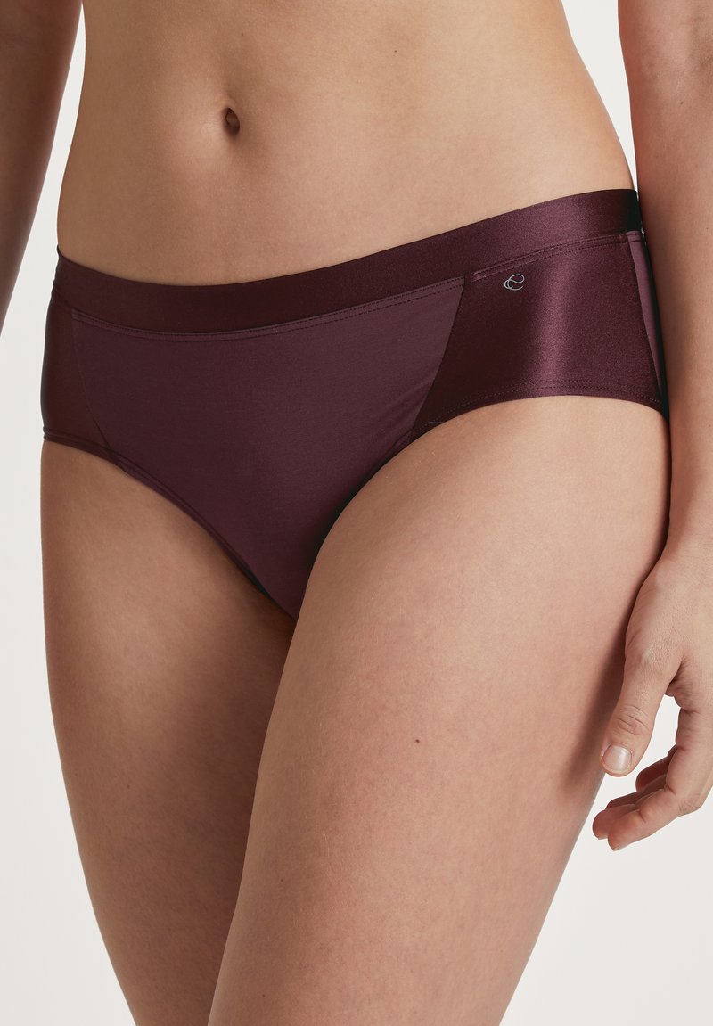 Bordeauxkleurige slipjes van een gladde stof met een semi-matte afwerking, voorzien van een brede band en contrasterende zijpanelen.