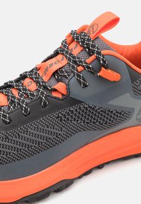 Schwarzer und grauer Sneaker mit orangen Akzenten, strukturiertem Mesh-Obermaterial, Gummisohle, reflektierenden Schnürsenkeln und einer verstärkten Zehenkappe für Langlebigkeit.