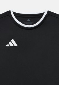 Μαύρο αθλητικό μπλουζάκι με λευκό γιακά, με λευκό λογότυπο Adidas στο στήθος. Κατασκευασμένο από λεία ύφασμα με εφαρμοστή γραμμή.