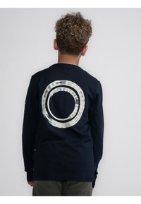 T-shirt a maniche lunghe blu con grafica circolare bianca sul retro; polsini a coste; realizzato in morbido cotone; vestibilità rilassata.