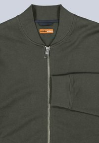 Olive green bomber jacket with ribbed collar and cuffs, zip closure, and horizontal textured fabric pattern. Logo tag visible.