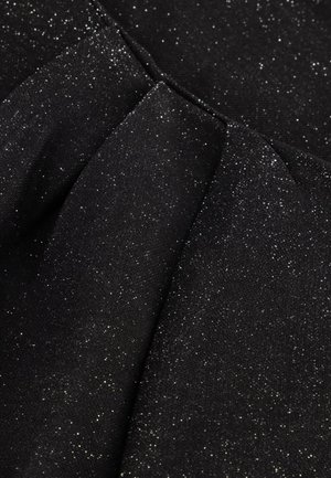 Zwarte stof met een subtiele glinsterende textuur, voorzien van plooien die diepte creëren. Het oppervlak heeft een fijne, glinsterende glans met gevarieerde lichtreflecties.