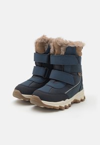 Niebieskie zimowe buty z futrzanym wykończeniem, z trzema rzepami, teksturowanym materiałem syntetycznym oraz wytrzymałą białą podeszwą z brązowymi akcentami.