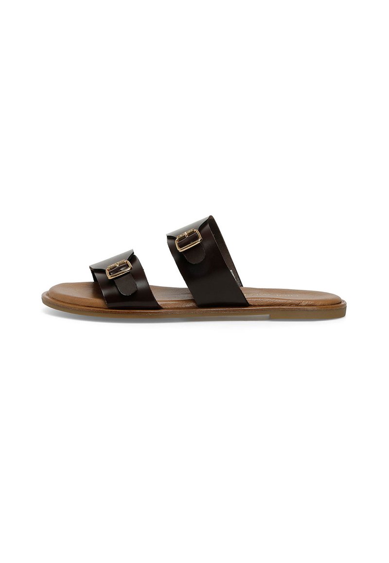 Brown leather sandals with two wide straps, each featuring a metallic buckle. Flat sole with a smooth brown base. Simple and minimalist design.