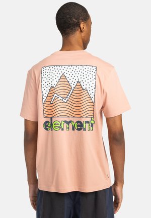 T-shirt en coton rose à manches courtes, ornée d'un graphique de montagnes avec des lignes ondulées et des points, et du mot "element" en texte vert gras.