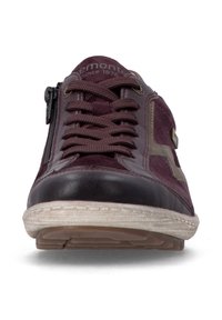 Vue de face d'une chaussure décontractée bordeaux avec lacets, fermeture éclair latérale, embout noir et semelle blanche texturée.