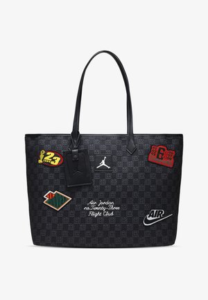 Juodas rankinis krepšys su raštuota tekstūra. Jame yra įvairių pleistrų ir dizainų, tokių kaip logotipai, tekstas ir spalvų akcentai.