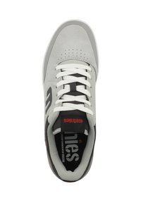 Šedé semišové tenisky s bílými tkaničkami, černými akcenty, perforovanou špičkou a potištěnou stélkou s názvem a logem značky.
