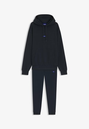 Musta hupullinen collegepaita, jossa on kiristysnyörit ja kengurutasku, yhdistetty vastaaviin jogger-housuihin, joissa molemmissa on pienet siniset brändilogot.