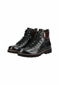 Botas de senderismo de cuero negro con un acento de cuero marrón en el tobillo, ojales de metal y una suela rugosa y con patrón. Los cordones están bien ajustados.