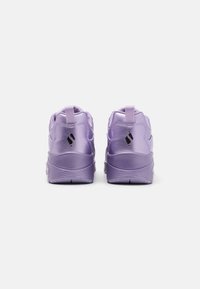 Sneakers atletici lavanda con una texture sintetica liscia, dotate di tallone rinforzato, suola in gomma e linguetta per indossarli facilmente.
