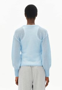 Lichtblauwe trui met lange, pofmouwen en een gestructureerde afwerking. Voorzien van een ronde hals en geribbelde manchetten. Zacht, lichtgewicht materiaal.