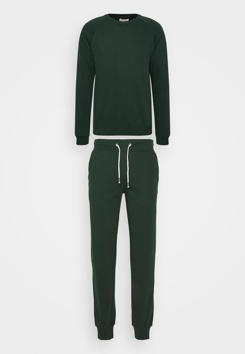 Grüner Pullover mit Raglanärmeln und Rundhalsausschnitt, kombiniert mit passenden Jogginghosen, die über einen elastischen Bund und Kordeln verfügen.
