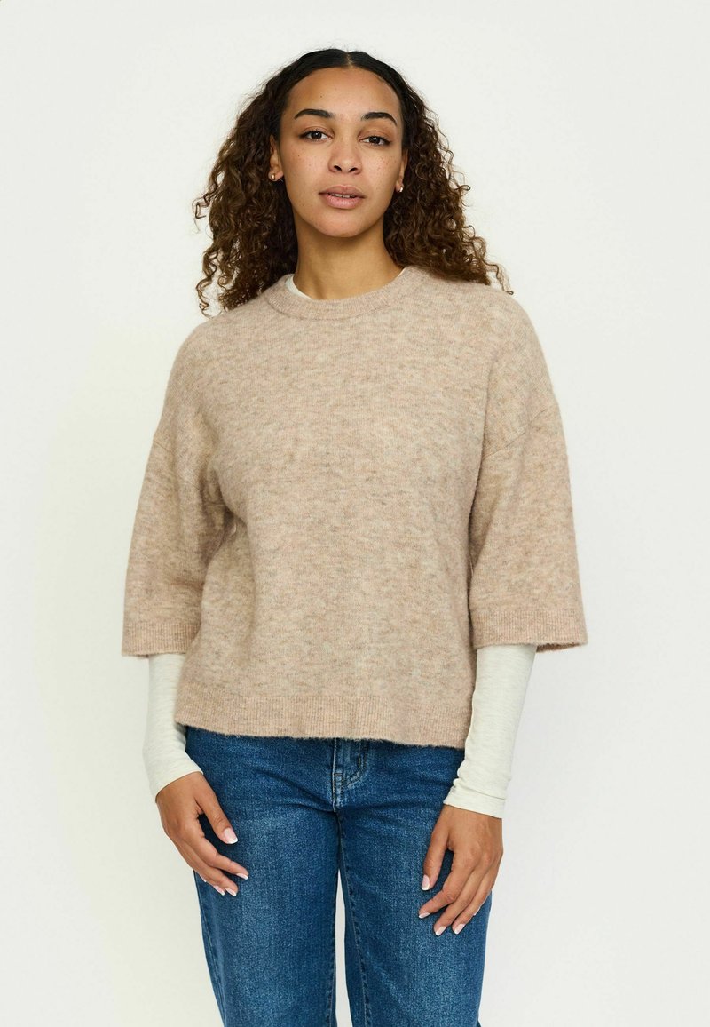 Helebeež plekk-sviiter lühikeste varrukatega ja ümmarguse kaelusega, millel on pehme tekstuur ja mugav lõige. Ühendatud siniste teksadega.