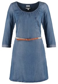 Denim sininen mekko, jossa on kolme neljännes -hihaa, pyöreä pääntie, rintatasku ja ohut ruskea vyö, jossa on valkoinen punottu yksityiskohta.